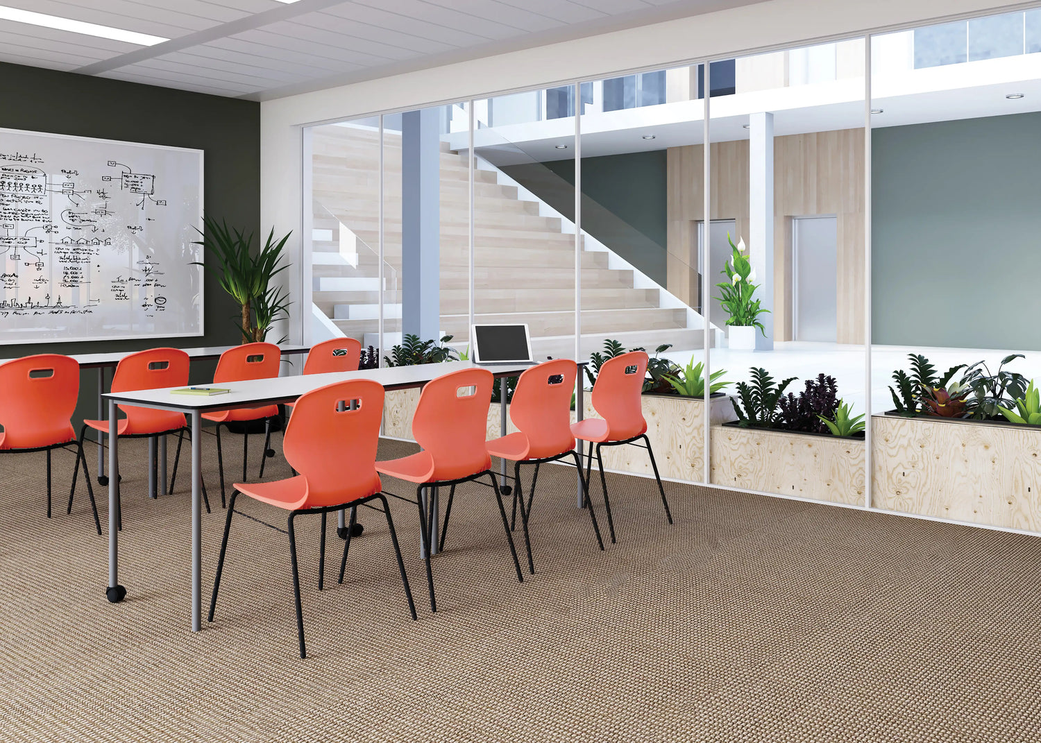 Modern office space with red chairs, a whiteboard, and a laptop.